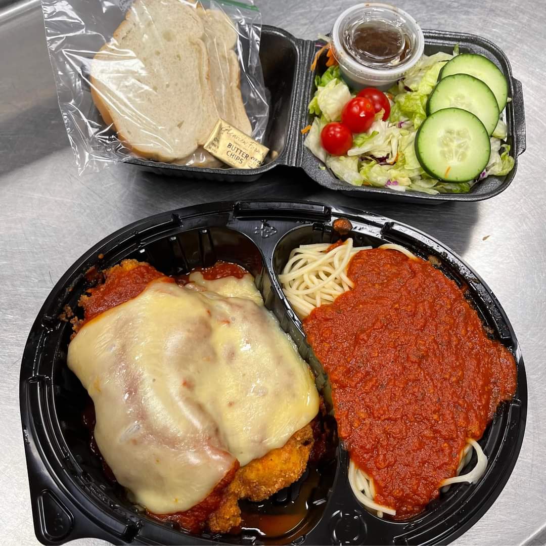 Chicken parmesan with spaghetti, salad, and bread